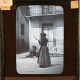 [Woman holding distaff in square in unidentified town]