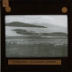 [View of shore with islands and distant mountains]
