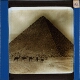 [People riding camels in front of Egyptian pyramid]