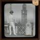 [Man wearing colonial helmet posing with Rajabai Clock Tower in background]