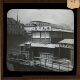 [Houseboat on waterway in unidentified town or city]