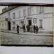 [Group of men standing outside hotel in French town or village]