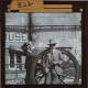 [Two men standing by field gun outside museum in French town or village]